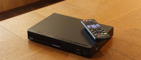 A black Panasonic DMP-BD88 media player on a wooden table.