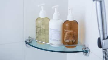 A bathroom shelf with three bottles of Provinscia shower gel.