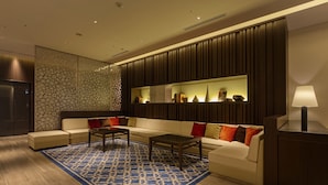 A modern living room with a sofa, coffee table, and decorative items on shelves. - Hotel Forza Hakataeki Chikushi - GuchiⅠ (Fukuoka)