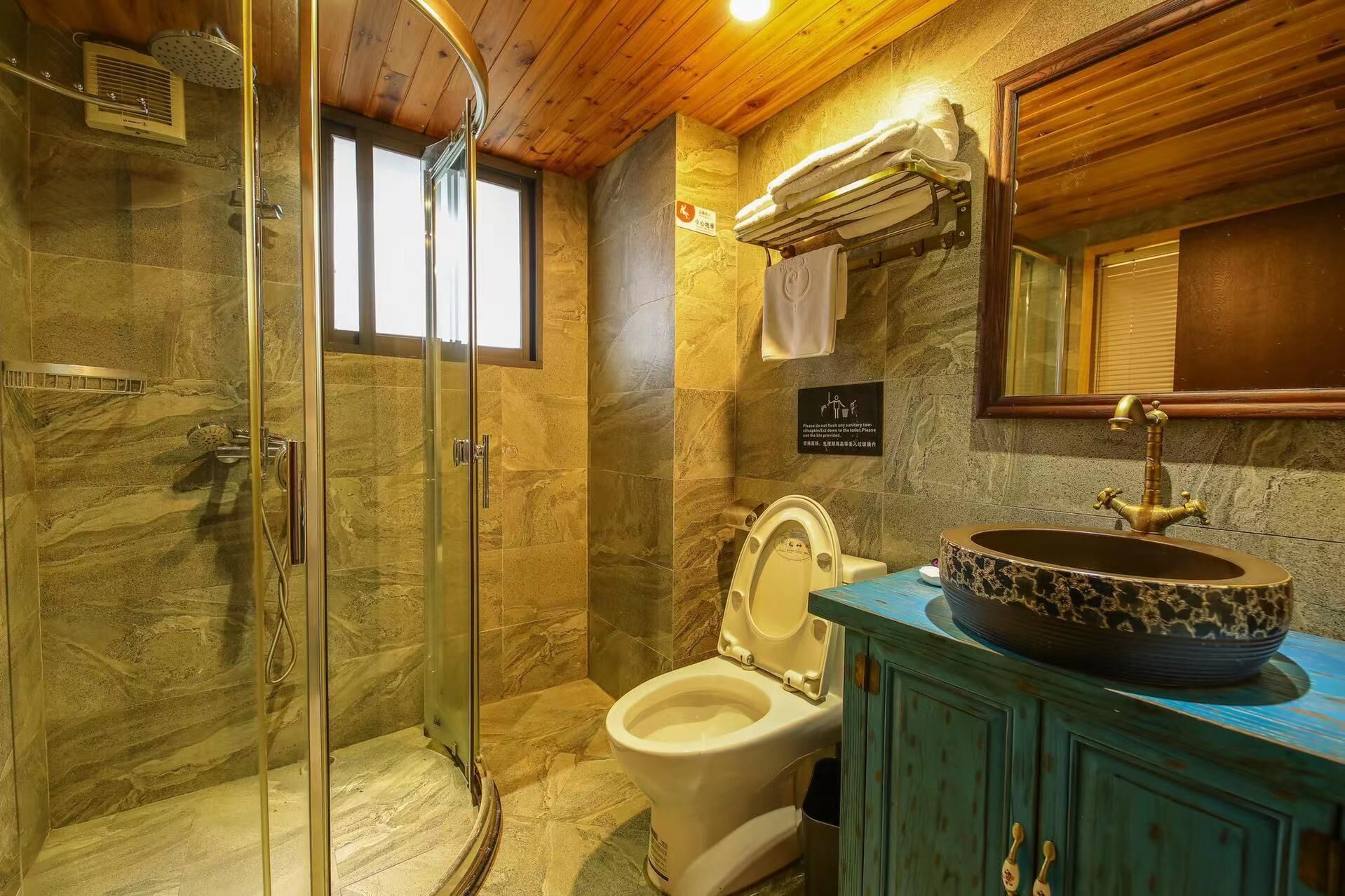 Ein Badezimmer mit Duschkabine, Toilette und Waschbecken mit dekorativer Schale.
