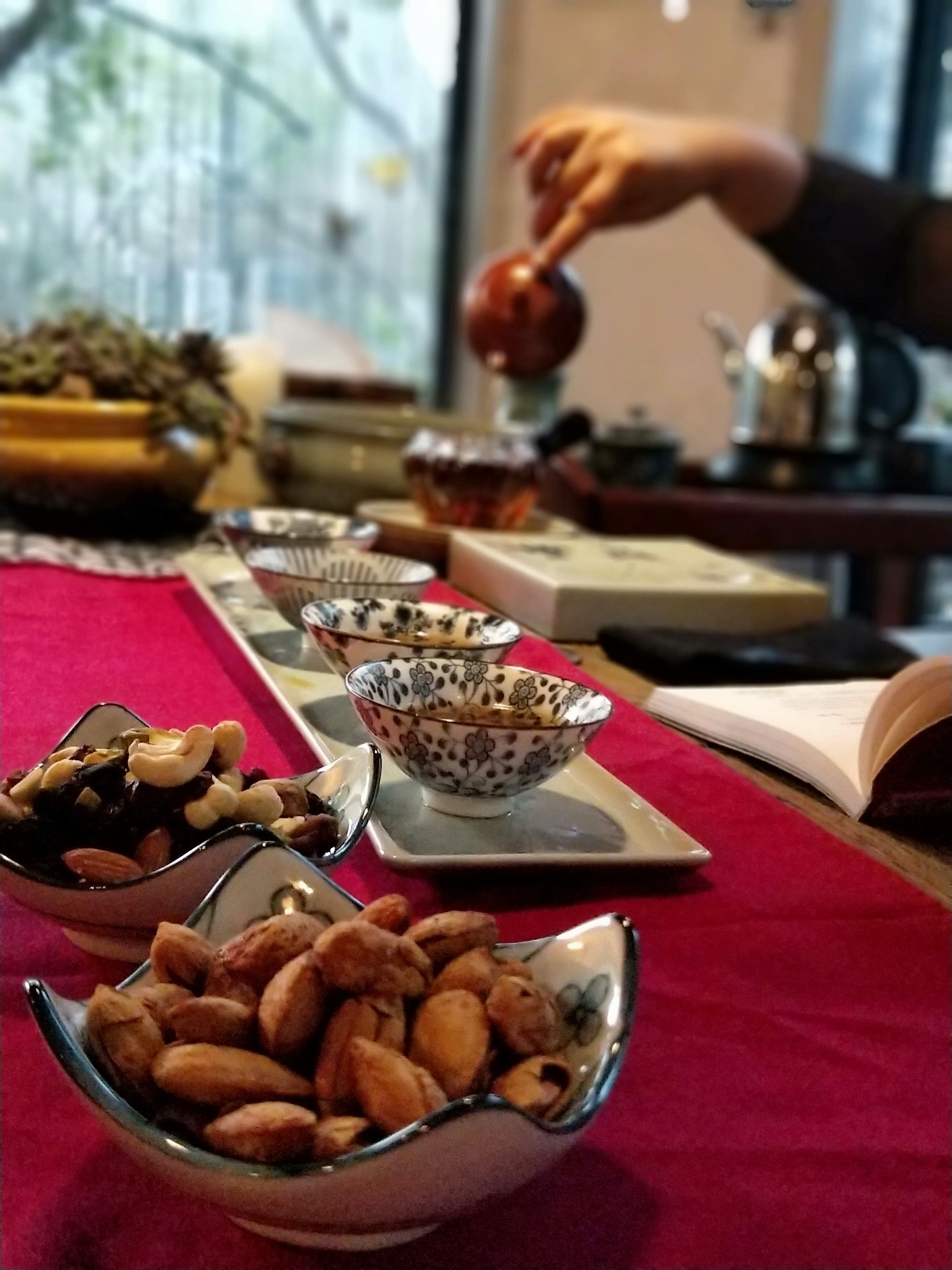 A table with various dishes and a person pouring tea.