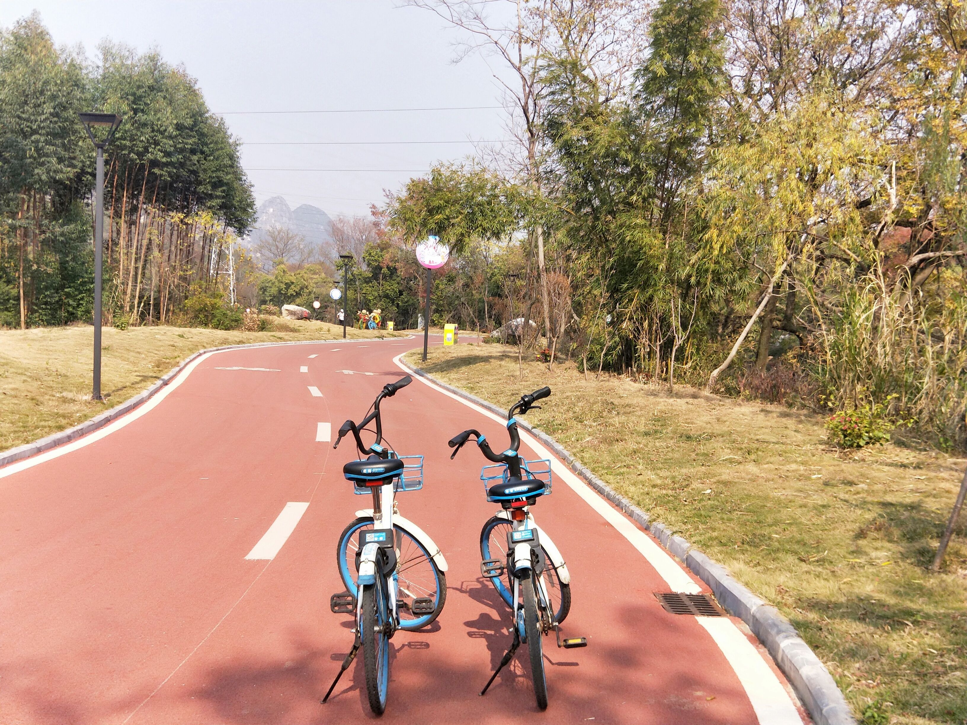 A red bike lane with two bicycles parked on the side.