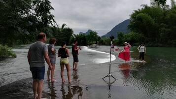 A group of people standing in a river with a camera on a tripod.