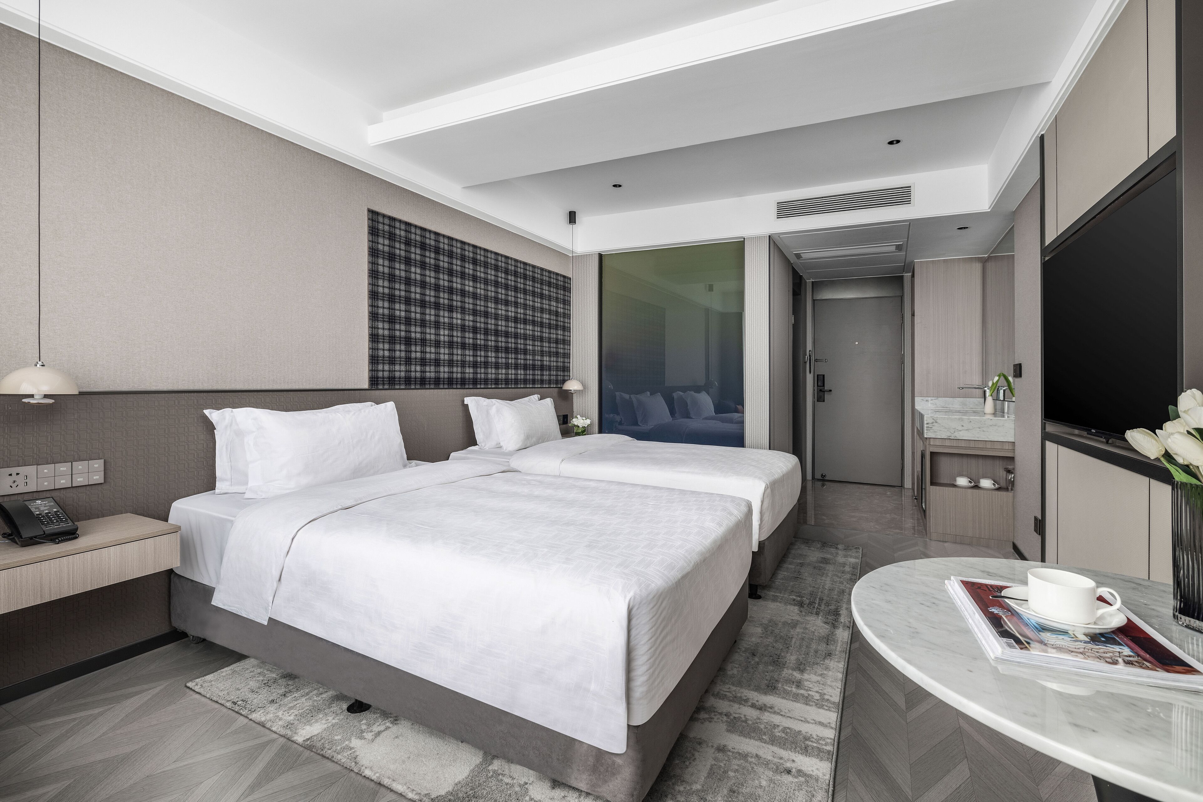 Une chambre d’hôtel moderne équipée d’un grand lit, d’un bureau, d’une salle de bain et d’une télévision.