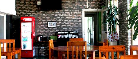 Un restaurante con paredes de ladrillo, muebles de madera y un refrigerador de Coca-Cola.