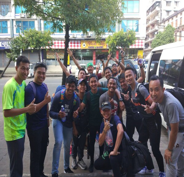 Un groupe de personnes posant pour une photo dans une rue de la ville.