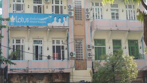 Un edificio de varios pisos con un letrero que indica una escuela de hotelería.