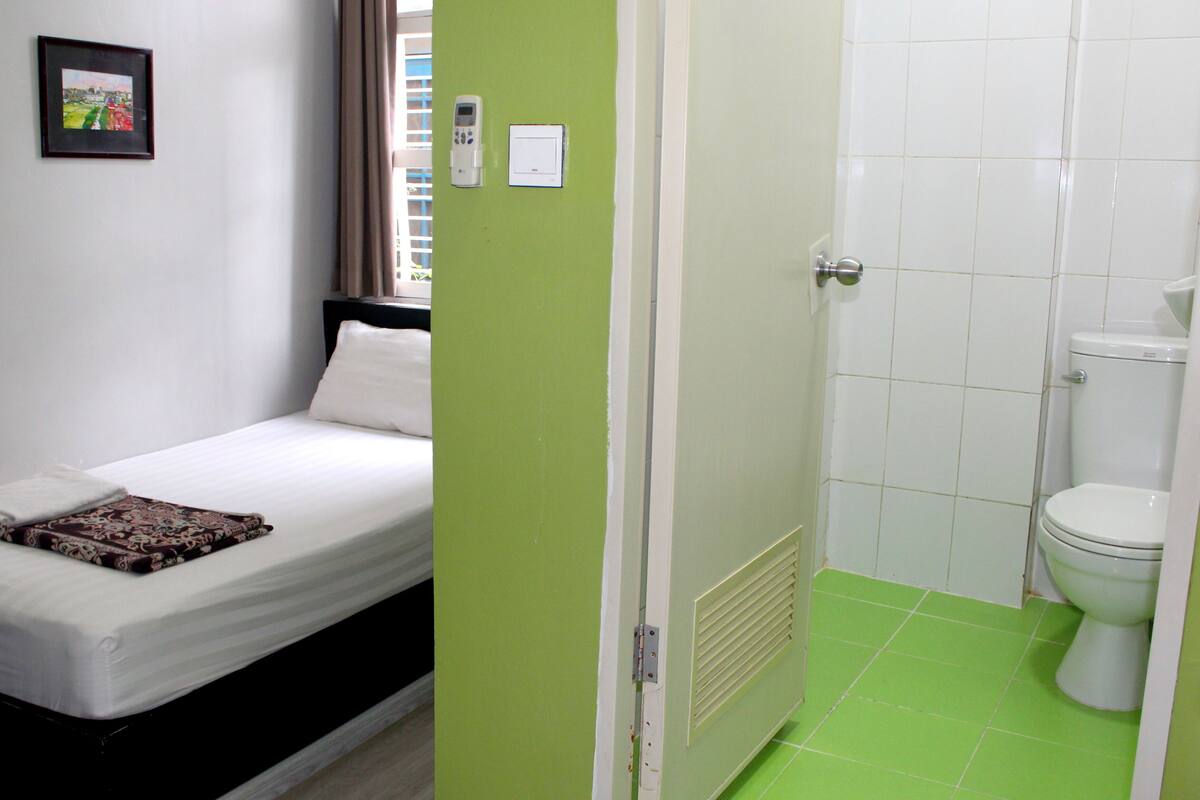 Un dormitorio con una cama, una mesita de noche y un cuadro en la pared.