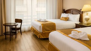 A hotel room with two beds, a wooden chair, a small table, and a lamp. - Al Jamal Hotel (Amman)