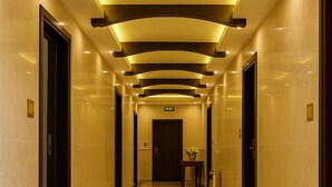 A long, well-lit hallway with a polished marble floor, leading to a door marked "EXIT". - Al Jamal Hotel (Amman)