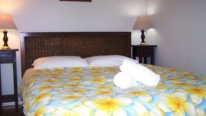 Quarto de hotel com uma cama, duas mesas de cabeceira e um quadro na parede.