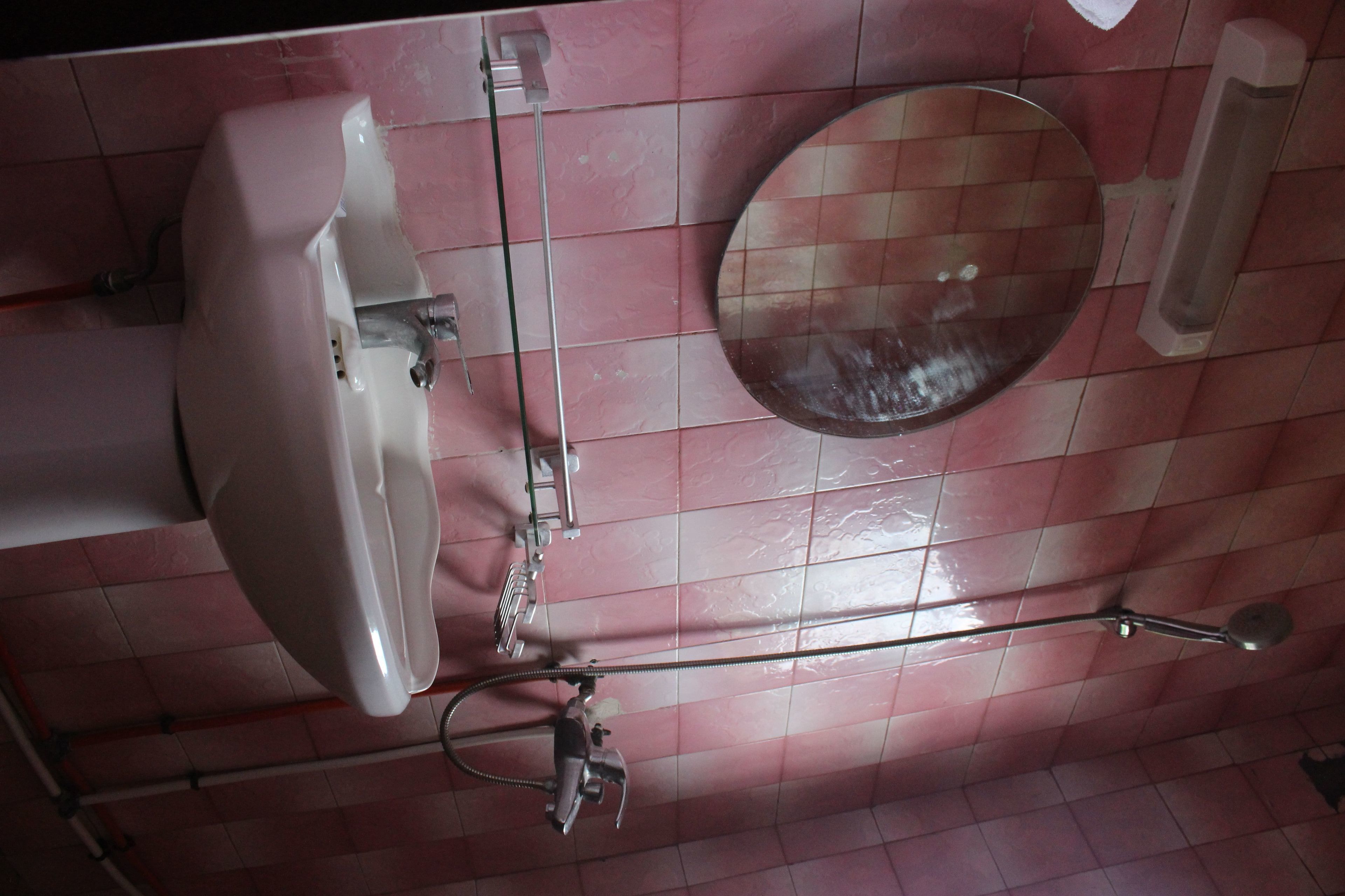 Un baño con lavamanos, espejo y ducha.
