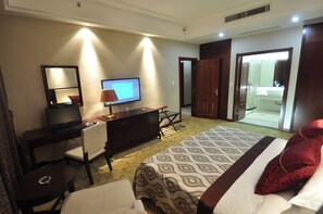 A hotel room with a bed, a desk with a computer, a television, and a bathroom visible through an open door. - Wuhan Guochuang Chuyuan East Lake Hotel (Wuhan)