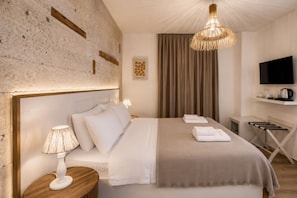 Een hotelkamer met een bed, nachtlampje, televisie en een tv aan de muur.