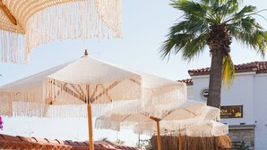 Een zwembadgedeelte met ligbedden en parasols.