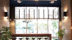 Eine moderne Lobby mit einem großen Fenster, einem Empfangsbereich und einer Kronleuchter.