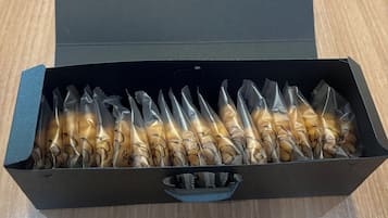Een zwarte doos met handvat, met daarin verschillende voorwerpen verpakt in doorzichtig plastic.