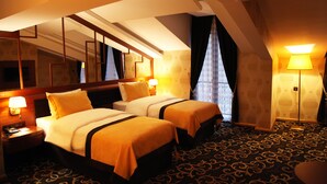 A hotel room with two beds, a large mirror, a nightstand, and a carpeted floor. - Grand Vuslat Hotel (Trabzon)