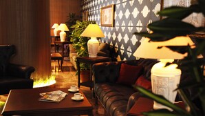 A cozy lounge area with leather sofas, a coffee table with magazines, and ambient lighting. - Grand Vuslat Hotel (Trabzon)