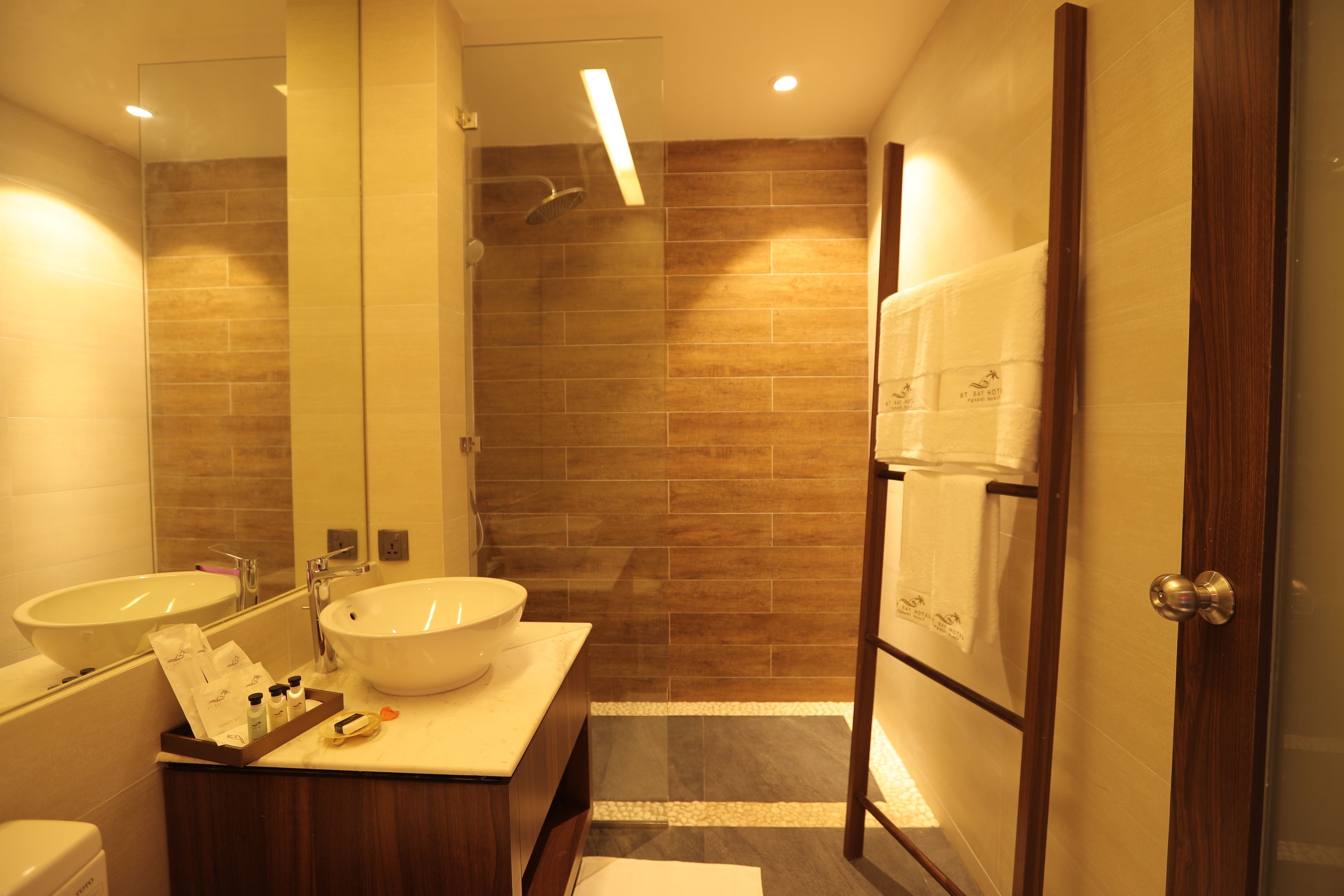 Un baño moderno con dos lavamanos, un espejo grande y una zona de ducha.