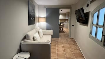 Apartamento Premium | Zona de estar | Televisión de pantalla plana de 24 pulgadas con canales por satélite