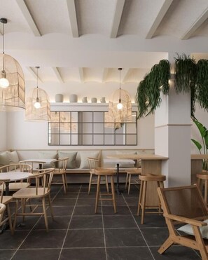 A modern cafe interior with wooden furniture, woven pendant lights, and a large mirror on the wall. - Hotel Caléndula  (Sant Feliu de Guixols)