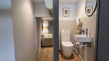 A modern bathroom with a toilet, sink, and shower area.