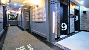 A hotel corridor with lockers, a reception area, and a number 9 door. - Instar Hotel Yangsan (Yangsan)