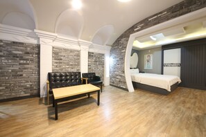 A bedroom with a bed, a bench, and a seating area with a sofa and chairs. - Instar Hotel Yangsan (Yangsan)