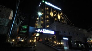 A building with a prominent 'AINSLEY' sign at the entrance, a staircase leading up to the main entrance, and multiple illuminated windows. - Instar Hotel Yangsan (Yangsan)
