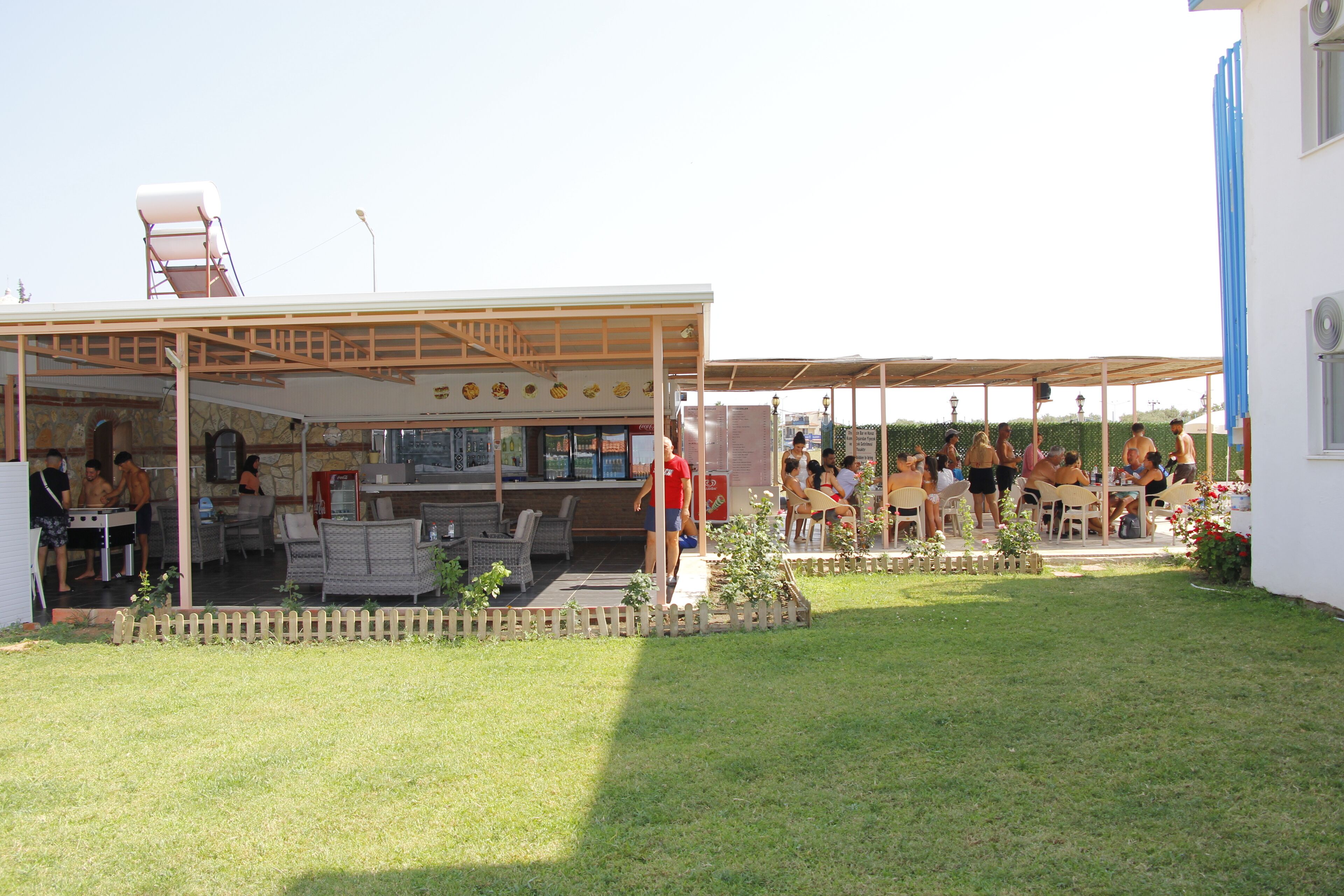 An outdoor patio area with tables and chairs, a covered seating area, and a small garden.
