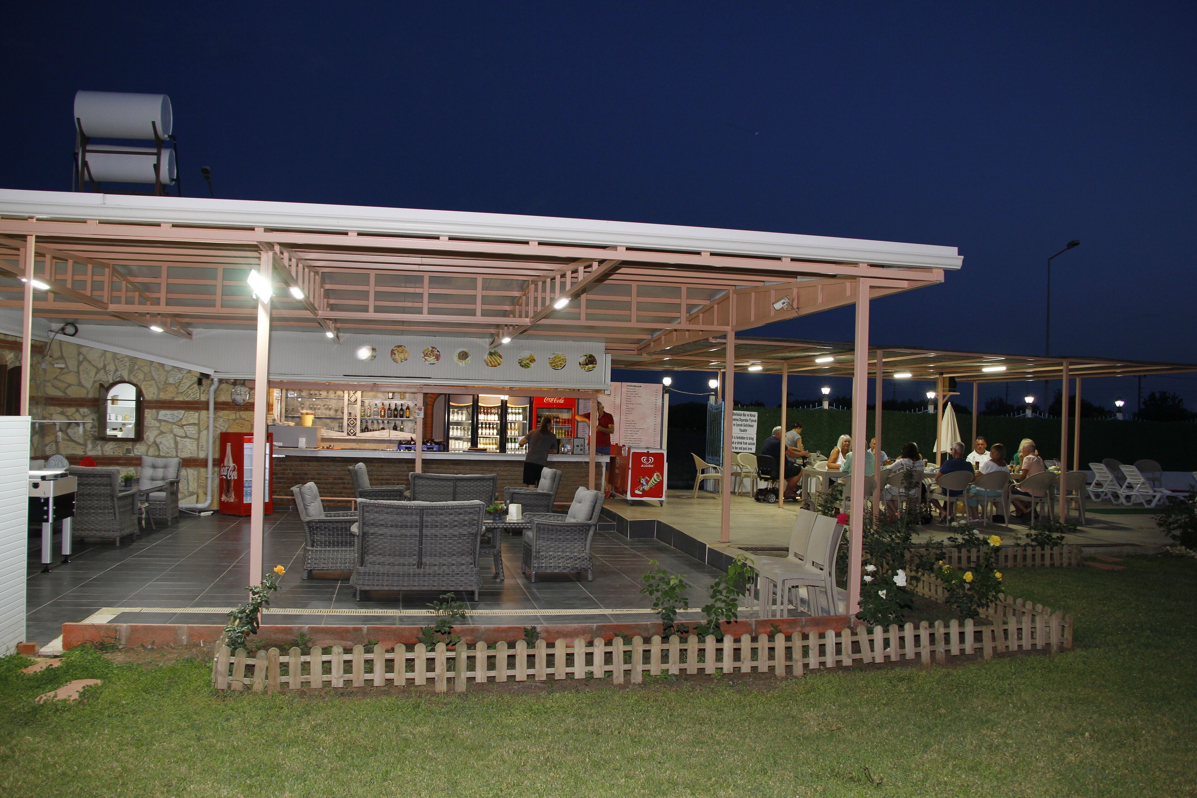 Un patio al aire libre con mobiliario y una barra.