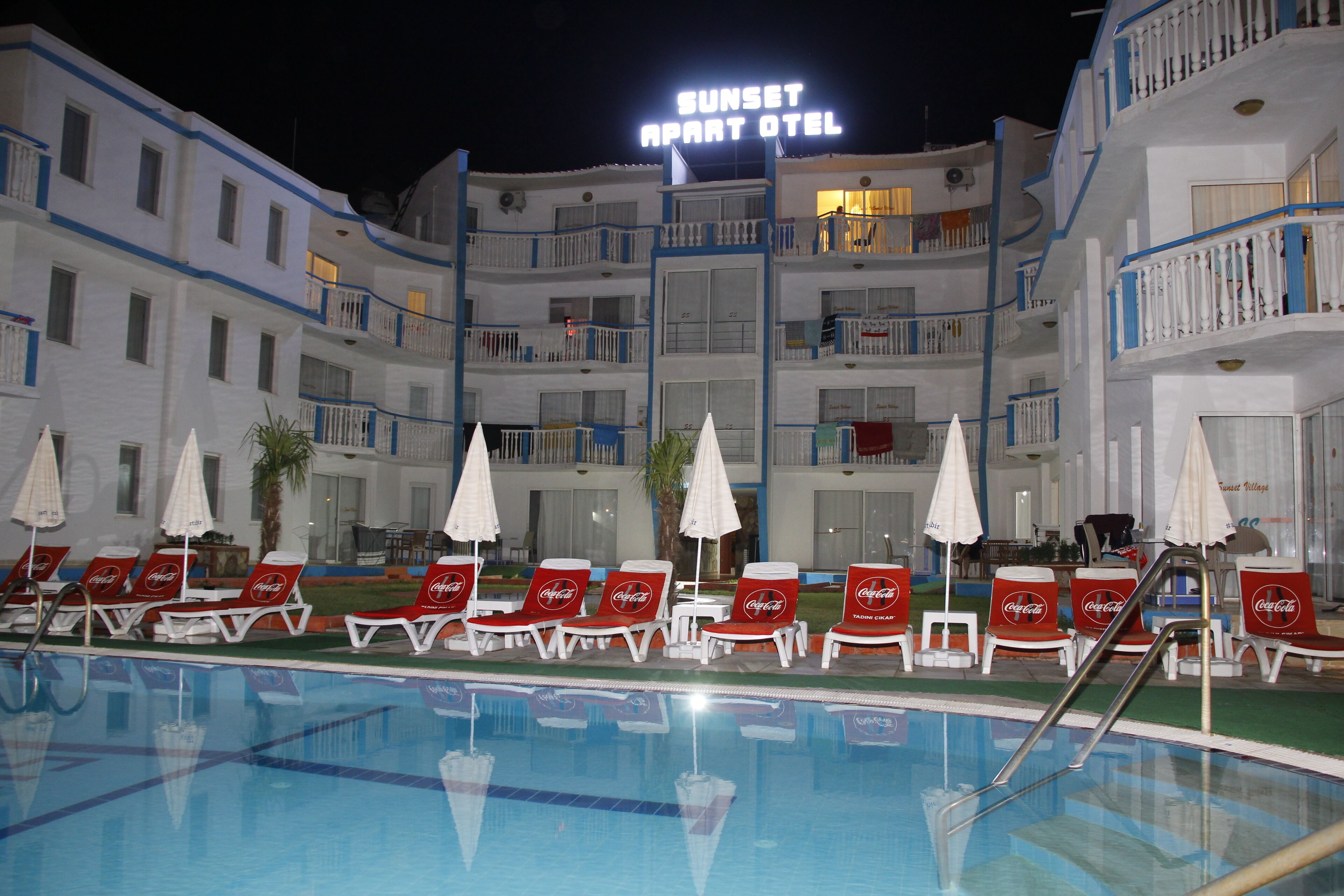 Hotel amb piscina, gandules i ombrelles.
