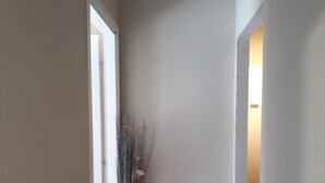 A narrow hallway with a tiled floor and a door on the left. - 48 airport budget rooms (Pisa)