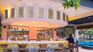 Un espace bar avec un comptoir, des tabourets et une vue sur l’extérieur.
