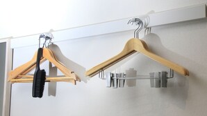 A wall-mounted drying rack with wooden hangers and a metal hook. - Center Hotel Tokyo (Tokyo)