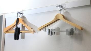 A wall-mounted drying rack with wooden hangers and a metal hook.