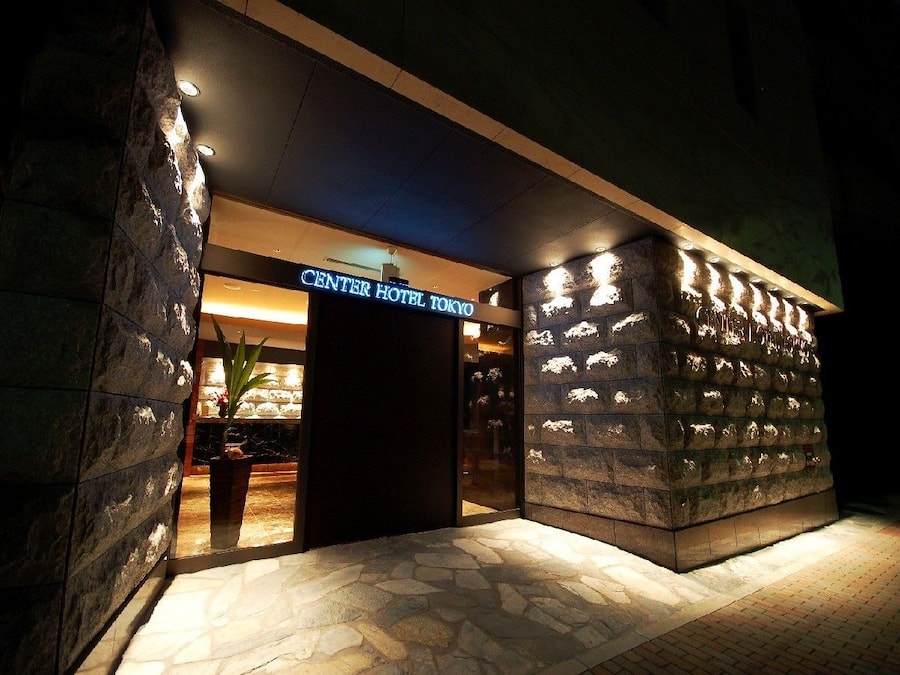 The exterior of the Center Hotel Tokyo with a stone facade and illuminated signage.
