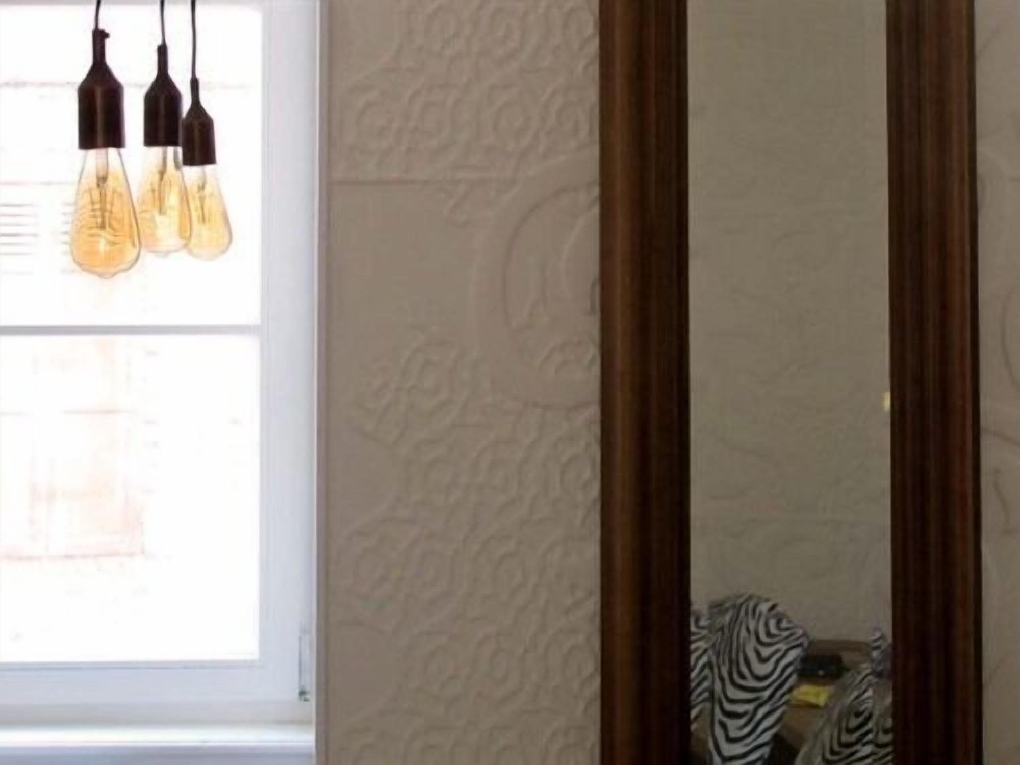 A room with a window, a wooden door, and a zebra-patterned rug.