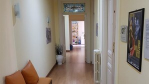 A hallway with a bench, a radiator, and a poster on the wall.