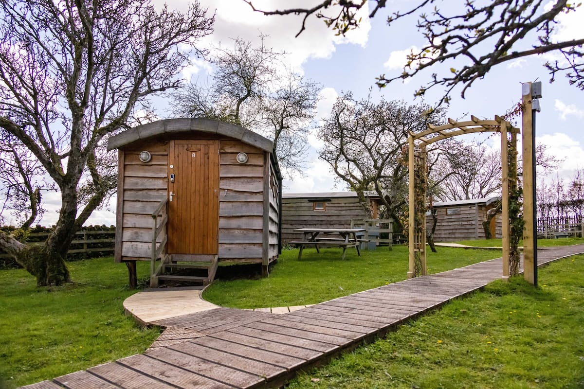A wooden cabin with a wooden door and a small porch.