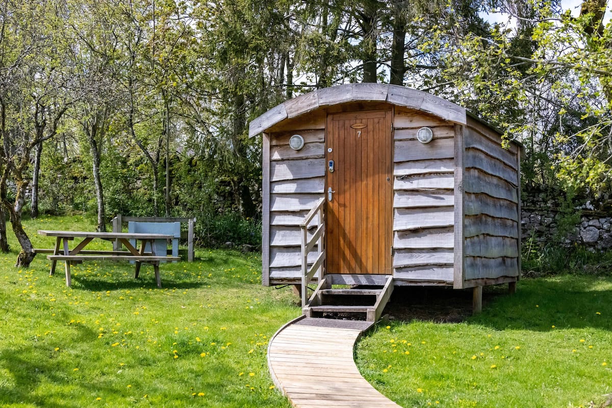 A wooden cabin with a wooden door and a small porch.