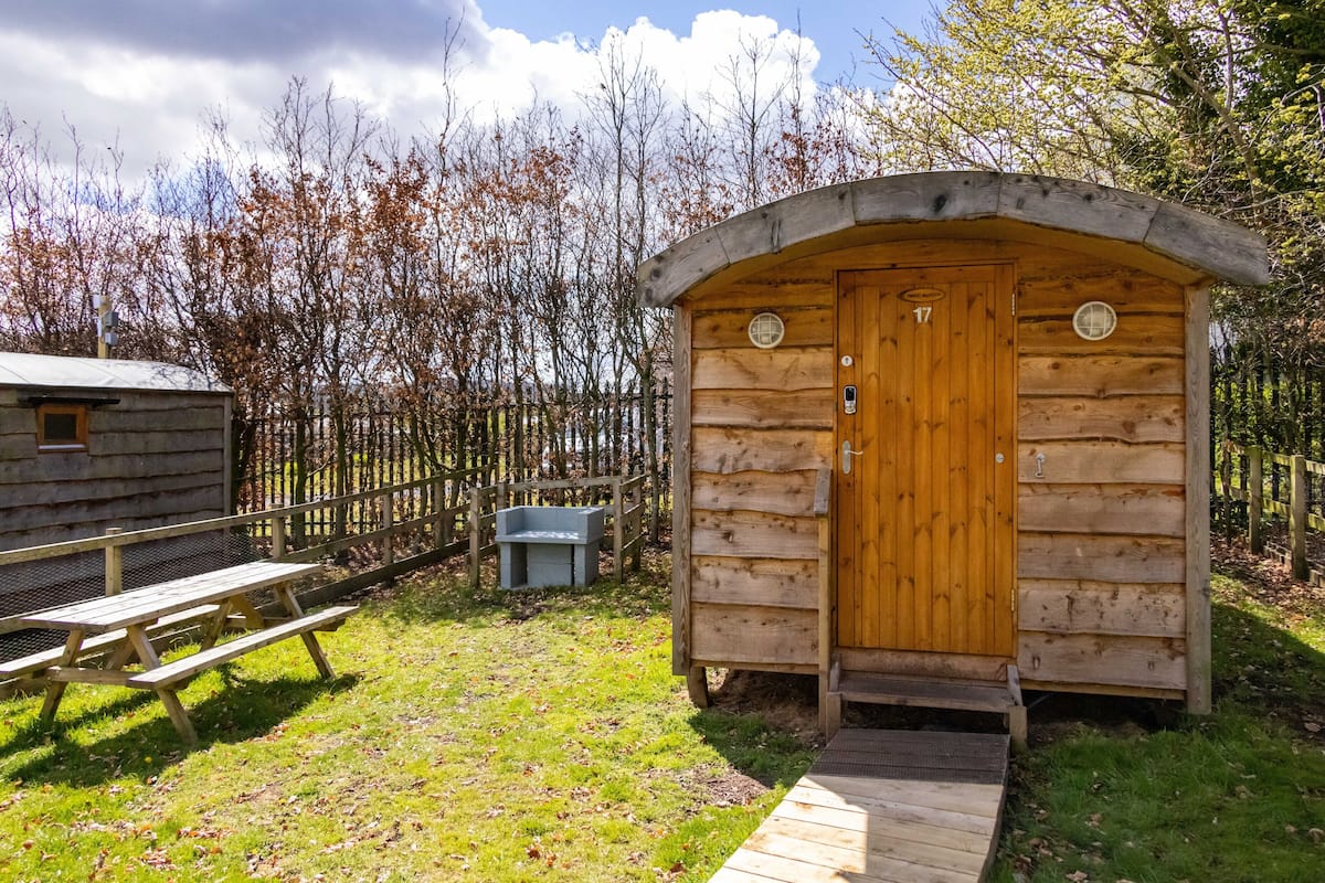 A wooden cabin with a wooden door and a small porch.