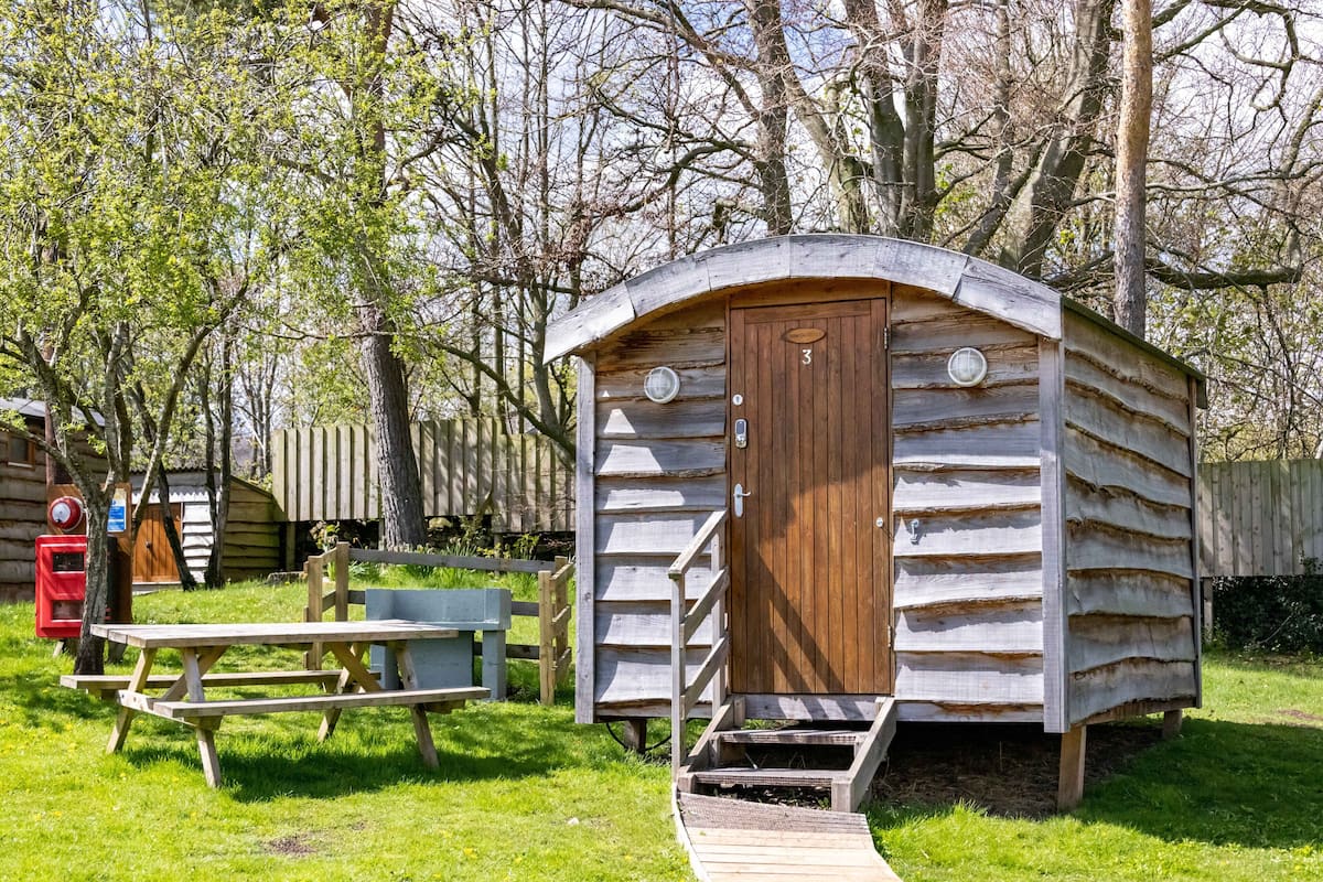 A wooden cabin with a door and a small porch.