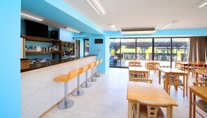 Un restaurant doté d’un bar, de tables et de chaises en bois.