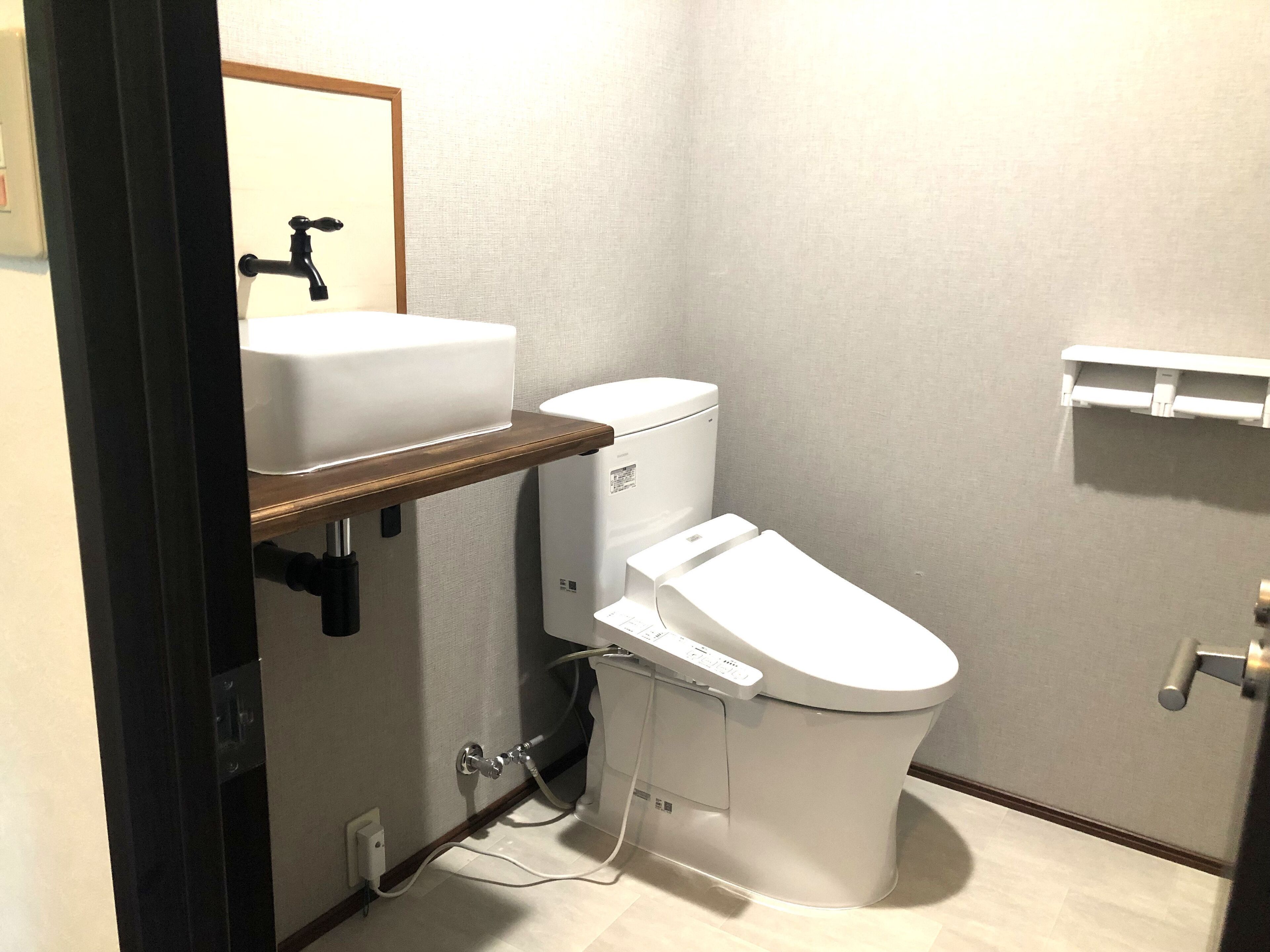 A small bathroom with a toilet, a sink, and a mirror.