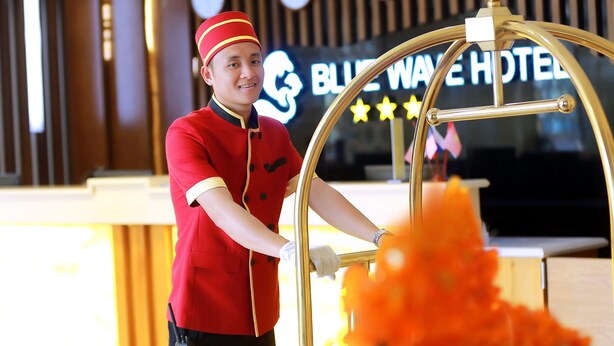 Un hall d'accueil d'hôtel avec une enseigne indiquant « BLUE WAVE HOTEL ».