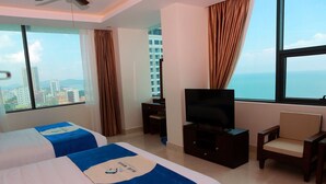 Une chambre d’hôtel avec deux lits, une télévision, un bureau et une chaise.