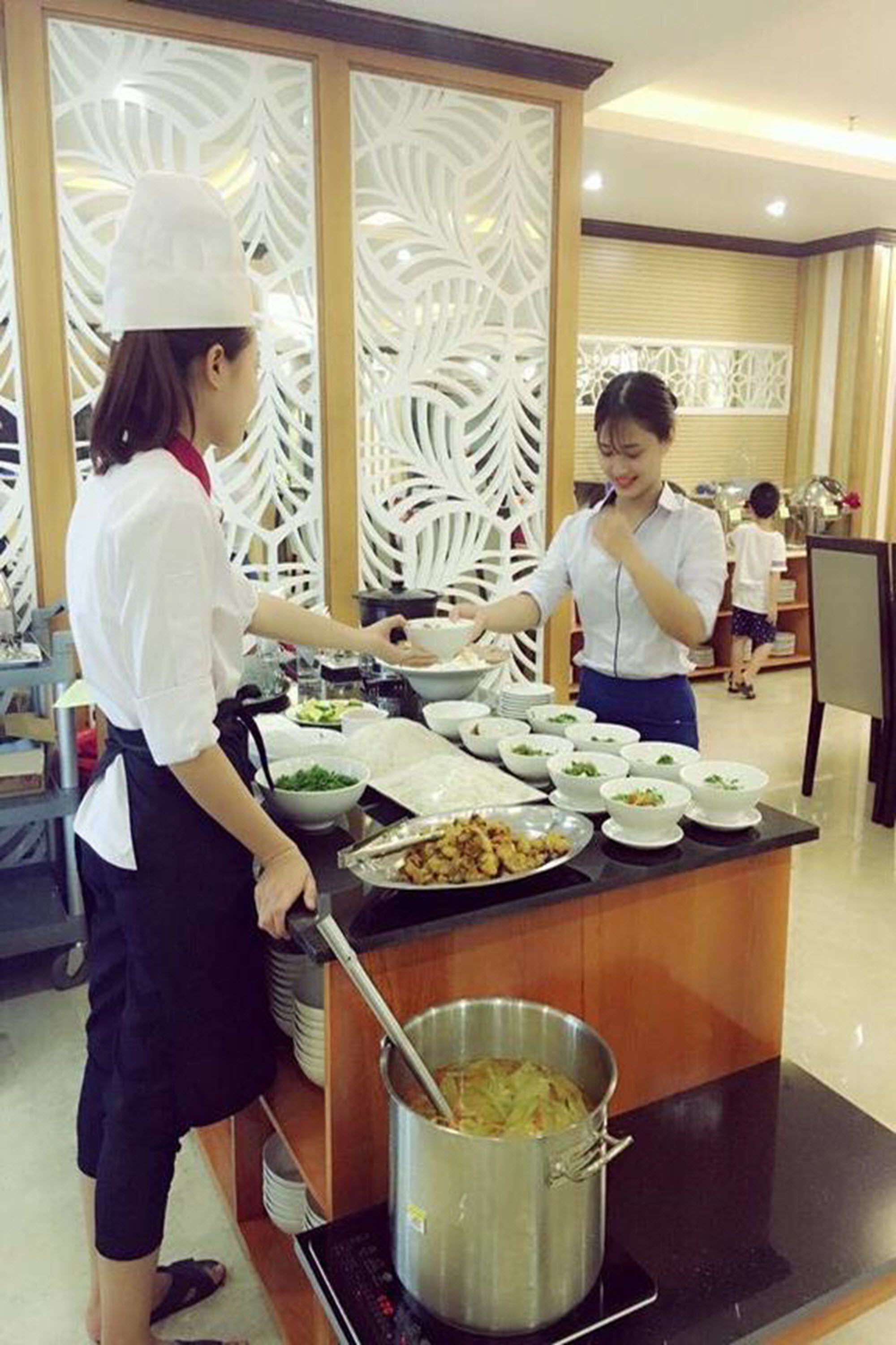 A buffet setup with multiple dishes and a cooking station.