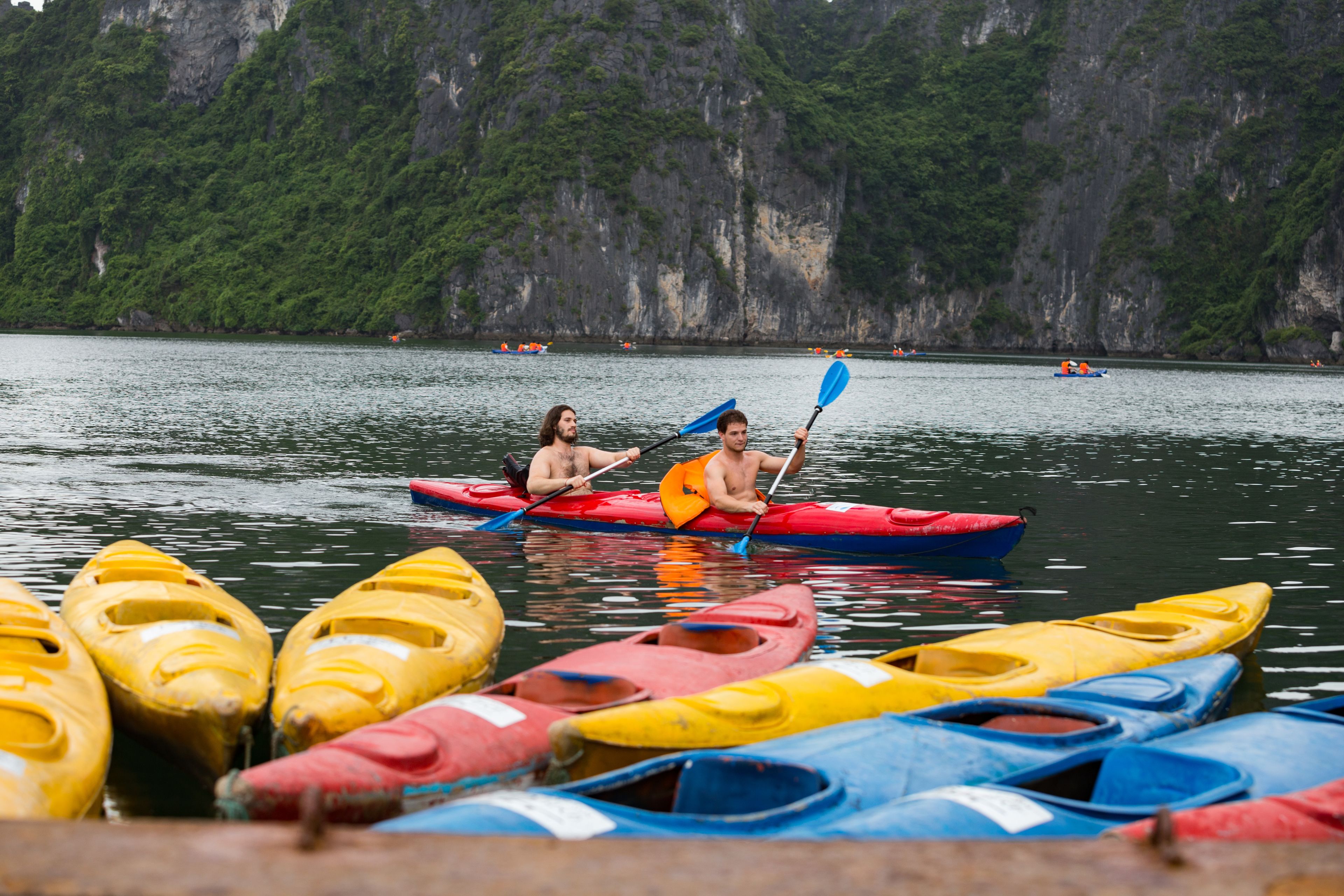 A calm lake with several kayaks and canoes docked along the shore.